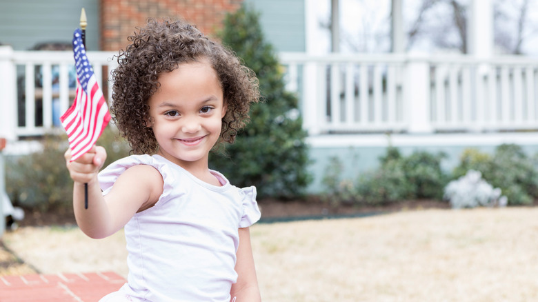 Girl with curly hair holding American flag