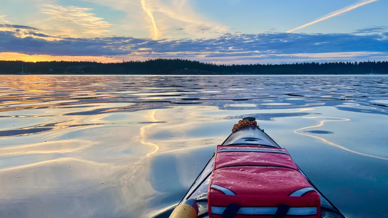 Kayak on the water with beautiful orange and blue sky sunset colours and clouds